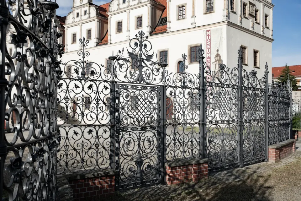 Schmiedezaun vor der Fassade des Johannbaus
