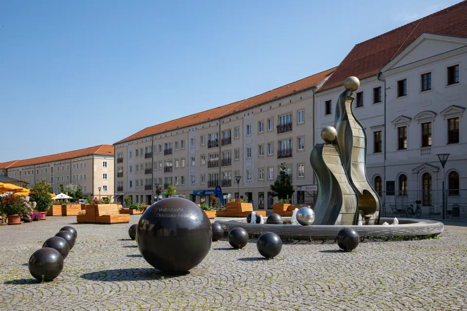 Brunnenanlage mit Bronzeskulptur zwischen Stadthäusern