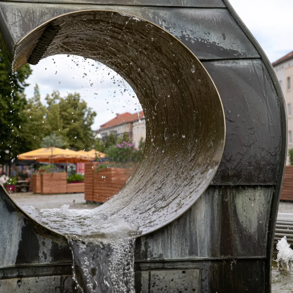 Brunnenskulptur in der Gesamtansicht vor historischer Fassade