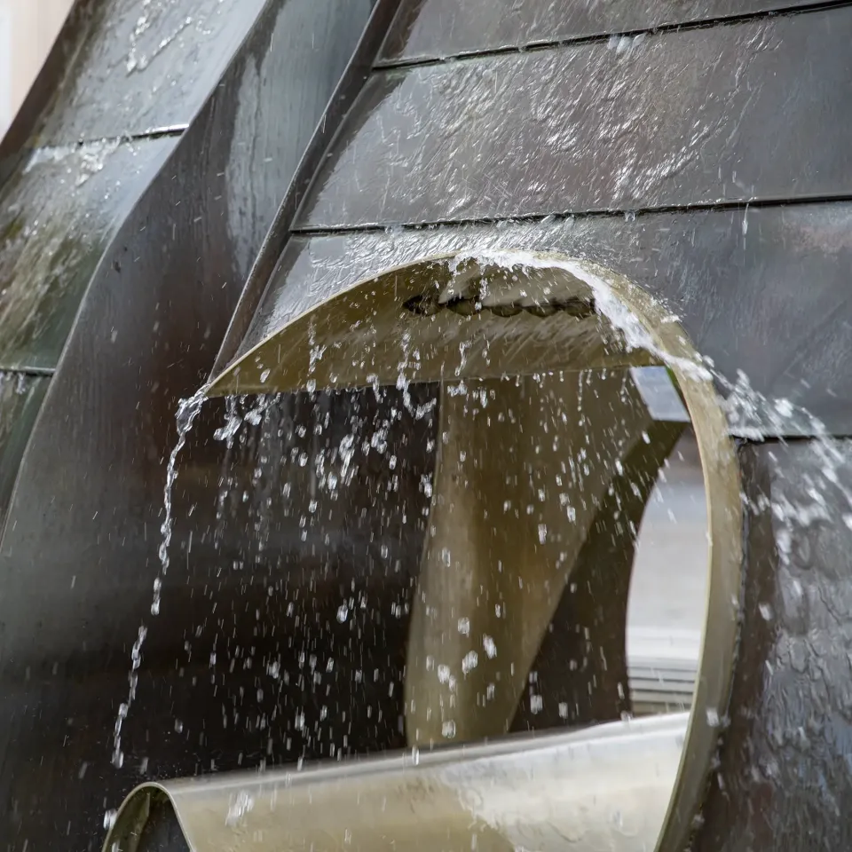 Wasser fließt durch einen Ring der Brunnenskulptur