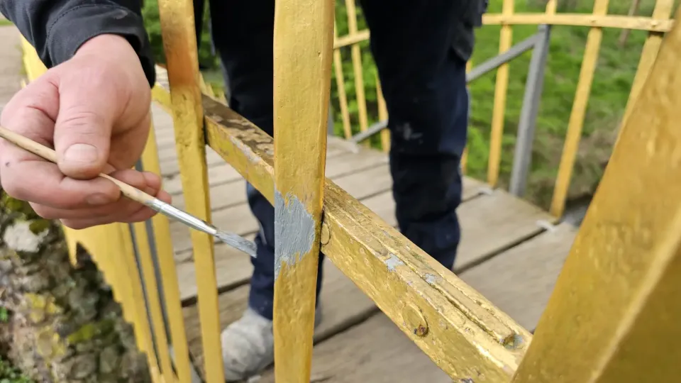 Feinarbeit mit dem Pinsel am Brückengeländer